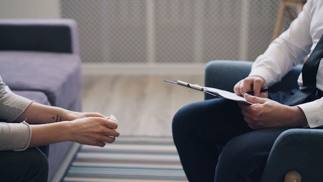 two people sitting with clipboard two people sitting with clipboard