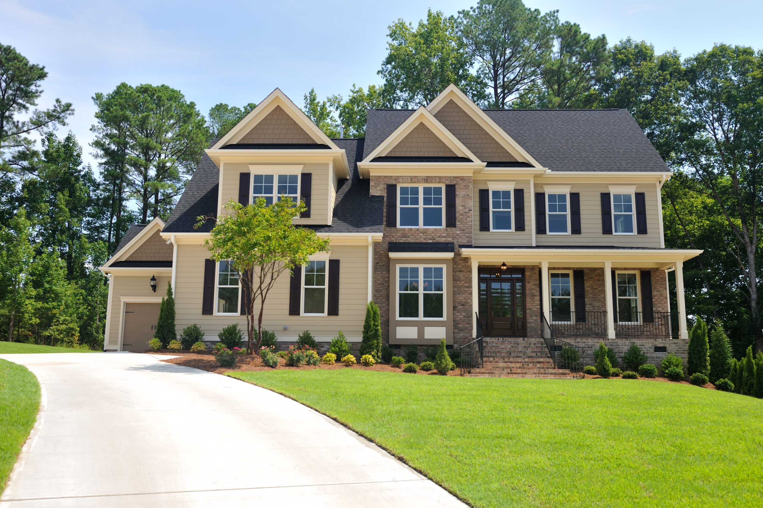 brown house with curved driveway and green lawn